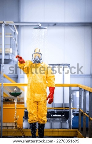Worker in chemicals production plant taking a shower to wash away the acid after the accident. Occupational health and safety. Royalty-Free Stock Photo #2278351695