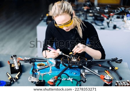 Engineer working on racing fpv drone combat kamikaze bomber in workshop. Royalty-Free Stock Photo #2278353271