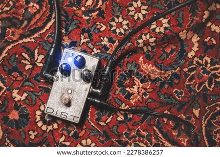 Rusty metal vintage distortion effect metal for guitar player on carpet with cables Royalty-Free Stock Photo #2278386257
