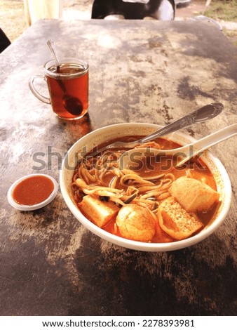 Pictures of curry noodles and hot tea. Breakfast is popular in Malaysia.