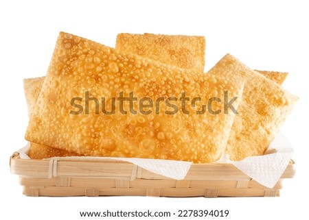Fried Pastels, Brazilian Pastel Frito, on a basket, white background Royalty-Free Stock Photo #2278394019