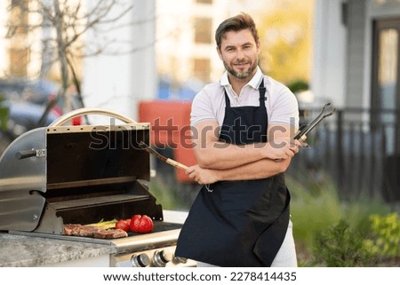 Barbecue master. Middle aged hispanic man in apron for barbecue. Roasting and grilling food. Man hold cooking utensils barbecue. Roasting meat outdoors. Barbecue and grill. Cooking meat in backyard. Royalty-Free Stock Photo #2278414435