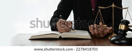 Female lawyer, legal counsel reading legal information book business deal with the other hand measuring the weight with the scales in order to determine the results of analyzing the correct principles Royalty-Free Stock Photo #2278418701