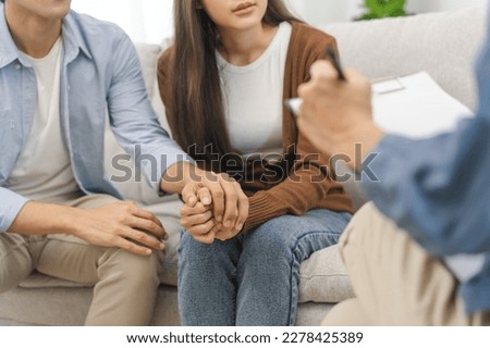 Psychology, depression asian young couple, patient consulting problem mental health with psychologist, psychiatrist at clinic together, husband encouraging by holding hand of wife, therapy health care Royalty-Free Stock Photo #2278425389
