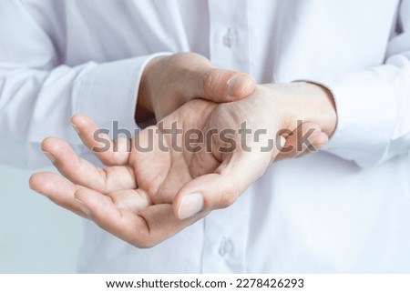 Hand of woman she massages his thumb and has finger pain, locked finger from work and office syndrome.  medical concept Royalty-Free Stock Photo #2278426293
