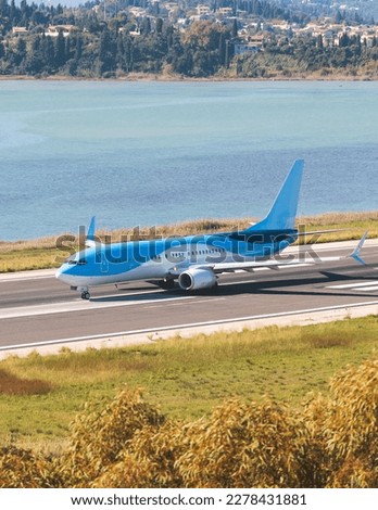 View of modern passenger plane aircraft on an runway airfield ready to take off, airstrip with commercial airplane before take off or after landing, airliner with mountains in a summer day Royalty-Free Stock Photo #2278431881