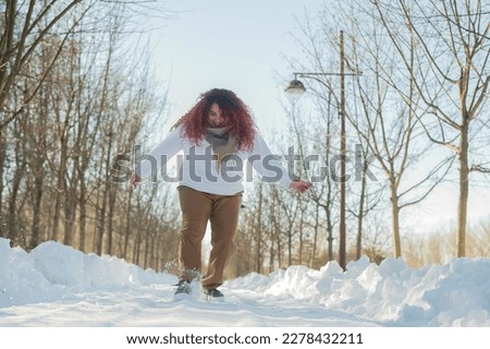 Smiling chubby redhead woman running in park in winter. 
