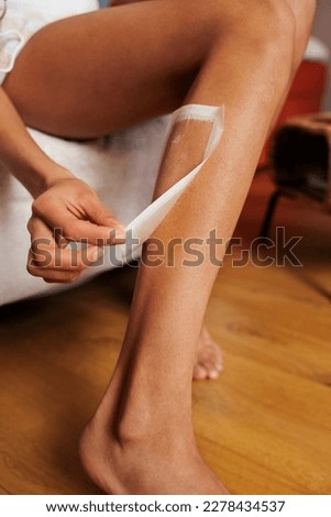 woman waxing leg. waxing female legs at home. young woman's leg for hair removal. Woman body care. waxing for legs with perfect smooth soft skin. beauty and health concept.
