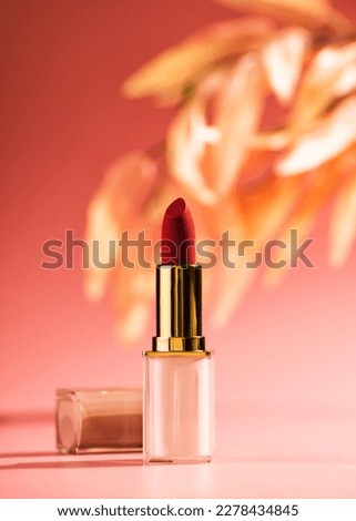 Red lipstick beauty product on a pink background