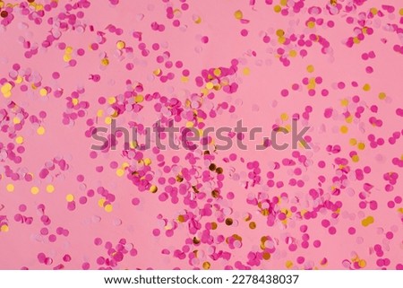 Gold and fuchsia confetti on a trendy pink pastel background. A festive background for your projects.