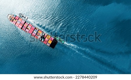 top view Cargo Container Ship with Tug boat carrying container and running very fast for export import cargo from container yard port to custom ,Contrail line in the ocean