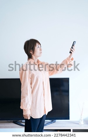 A woman holding a smartphone indoors