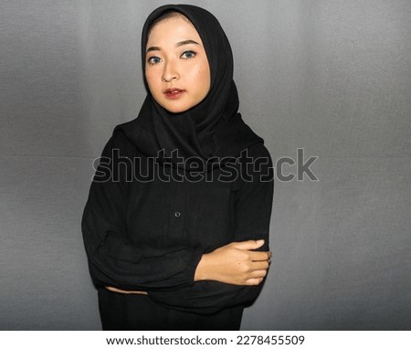 Beautiful Young Asian Hijab Girl Posed With Happy Expression and Give Hand Gesture on Isolated Black Background.