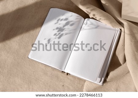 Open notepad blank sheets and floral sunlight shadows on a neutral beige linen background, mock up with copy space, aesthetic writer blog design template Royalty-Free Stock Photo #2278466113