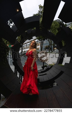 Young woman traveller in red dress looking beautiful landscape of singapore city with sunset sky , the most famous tourist attraction in singapore, Travel andvacation in singapore. 