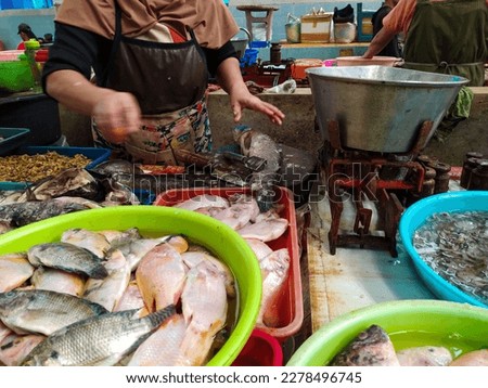 Fishmonger in a traditional market cleaning fish