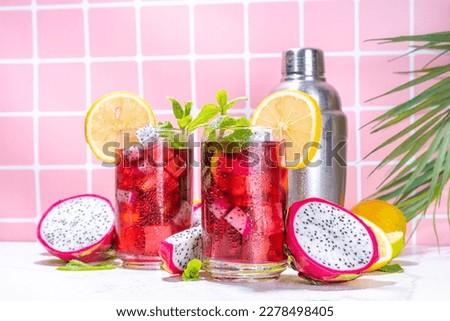 Sweet colorful tropical cocktail with pitaya or dragon fruit, lime and mint. Lemonade, mojito alcohol pitahaya fruit drink over light tile background copy space 