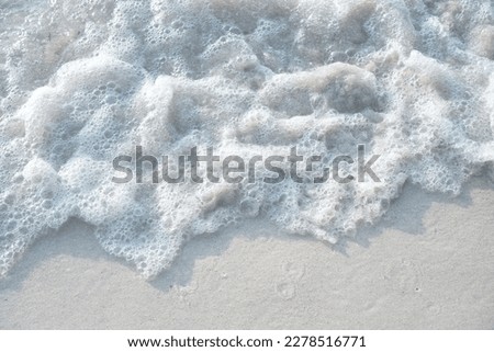 foamy waves and white sand on a beautiful sandy beach. Background