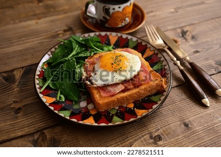 Fried egg and bacon open sandwich and coffee