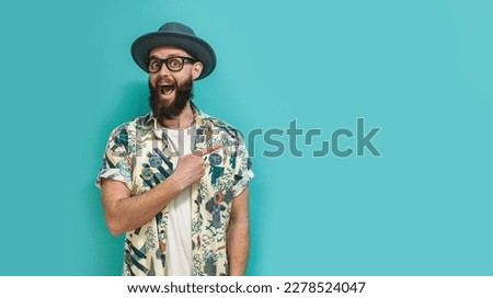 Hipster man in a Hawaiian shirt with a beard pointing with fingers at your text. Discount, sale, season sales.