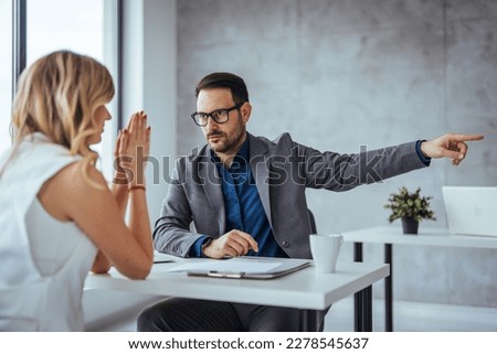 Director dissmissing worker. Getting fired. Angry boss pointing female employee on exit way. Mad male employee blaming female colleague. Get out of here. Angry boss outing his young office worker  Royalty-Free Stock Photo #2278545637