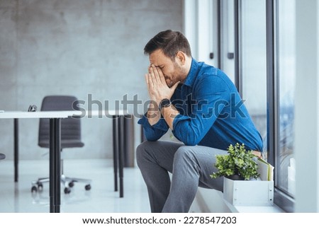 Unemployed guy in formal wear holding personal belongings, feeling depressed after losing his job. Upset Eastern man with cardboard box of things leaving office after being fired Royalty-Free Stock Photo #2278547203