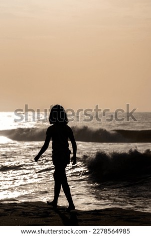Silhouette of a girl along a beautiful beach sunrise