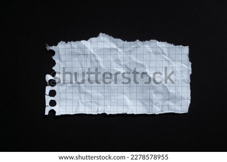 Ripped white graph paper on black background. Torn paper background with copy space.