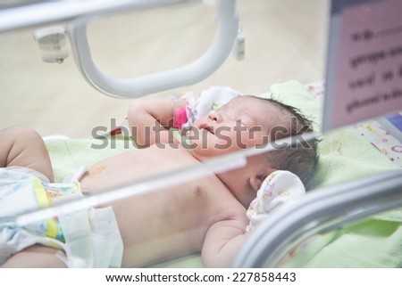 first day of asian newborn baby in Incubator care at nursery hospital Royalty-Free Stock Photo #227858443