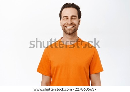 Smiling happy man with closed eyes, dreaming of smth, thinking with pleased carefree face, standing over white background. Royalty-Free Stock Photo #2278605637