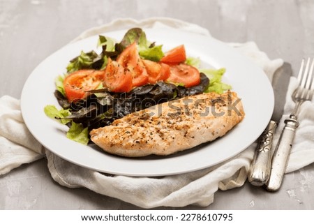 Baked turkey with vegetable fresh salad on white plate