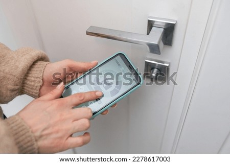 Hotel door security Unlocking by application on mobile phone. Digital door lock, key less system of access door. Close up Royalty-Free Stock Photo #2278617003