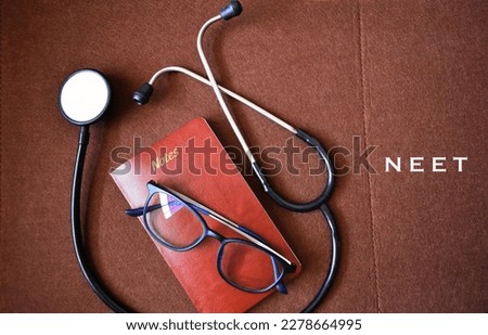 Medical entrance exam concept with stethoscope,glass and diary in closeup placed over brown background. Royalty-Free Stock Photo #2278664995
