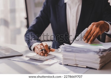 work from office A businessman works a bunch of paper files to find information on his desk at home. business report pile of unfinished documents Royalty-Free Stock Photo #2278669707