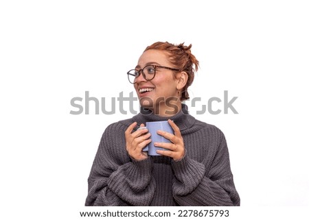 Young woman, with a cup of coffee, and coat, on a white background.