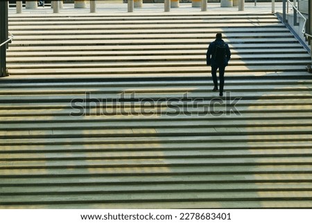 Lonely man backview walking upstairs Royalty-Free Stock Photo #2278683401