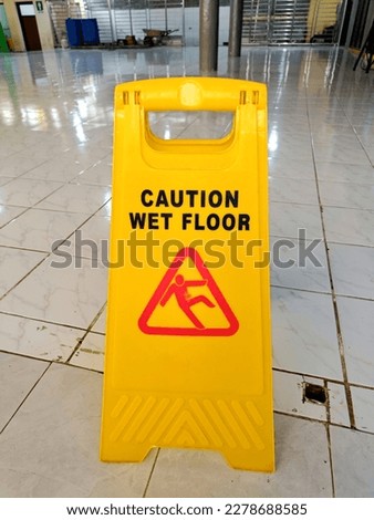 Warning signs. Seal the yellow plastic sign with Caution for Wet Floor written in the office hall after cleaning. The safety sign depicts a man sliding and slipping

￼


