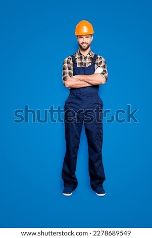 Full size fullbody portrait of cheerful joyful repairer in shirt and overall, having his arms crossed, looking at camera, isolated on grey background Royalty-Free Stock Photo #2278689549