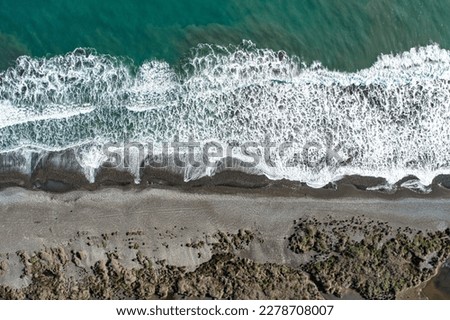 Aerial view of chilean ocean with black snd beach. Top view from drone