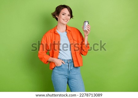 Photo of cheerful positive lady dressed jeans shirt rising lemonade can empty space isolated green color background Royalty-Free Stock Photo #2278713089
