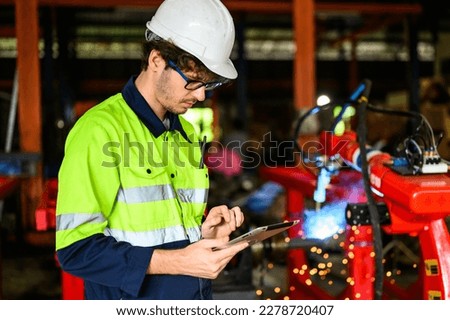 Young mechanical technician using tablet checking machine at warehouse