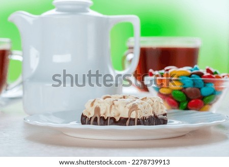 White plate with a chocolate dessert and a cup of tea.