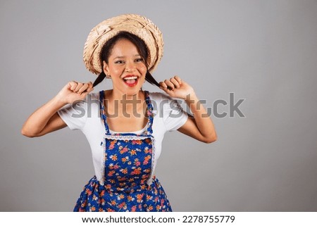 Brazilian woman, northeastern, with June party clothes, straw hat. posing for a photo.