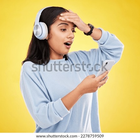 Shock, surprise and woman with phone, headphones and hand on head isolated on yellow background. Social media, music news or exciting online gossip, hispanic girl reading notification on smartphone.