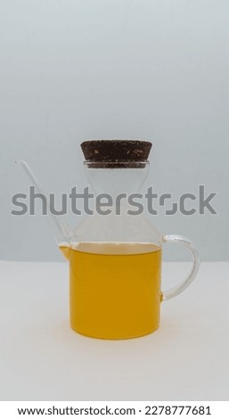 Unfiltered extra virgin olive oil in a small glass bottle isolated on a white background and close up.
