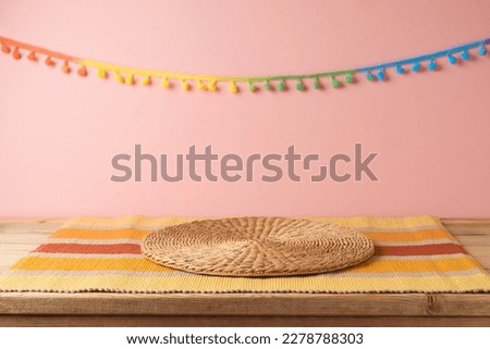 Empty wooden table with wicker place mat over pink wall  background. Mexican party mock up for design and product display Royalty-Free Stock Photo #2278788303