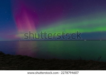 Unusual phenomena: Northern Lights also know as Aurora borealis above north of Zealand, Gilleleje, Denmark in end of February 2023. Strong pink and green lights and a starry night. 
