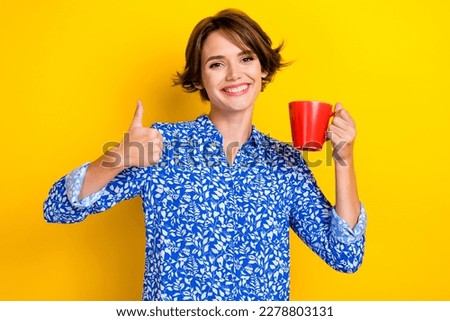 Photo of cheerful adorable lady wear blue stylish clothes thumb up nice feedback cafe restaurant isolated on yellow color background