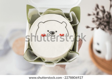 Small bento cake decorated with cute teddy bear silhouette and red hearts drawing. Cake as a gift for beloved one. Happy Valentine's cake