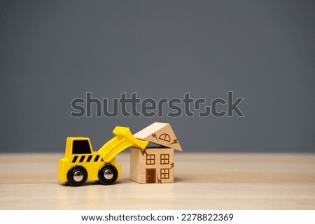 The bulldozer demolishes the house. Encroachment on private property. Illegal buildings and construction. Violation of building codes. Housing renovation. Renovation of an old real estate fund. Royalty-Free Stock Photo #2278822369